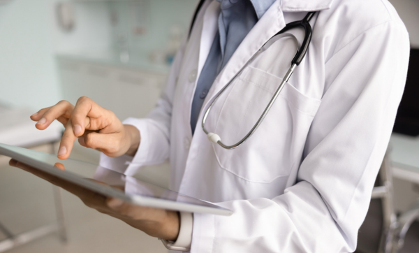 Young female medical practitioner woman touching screen of gadget
