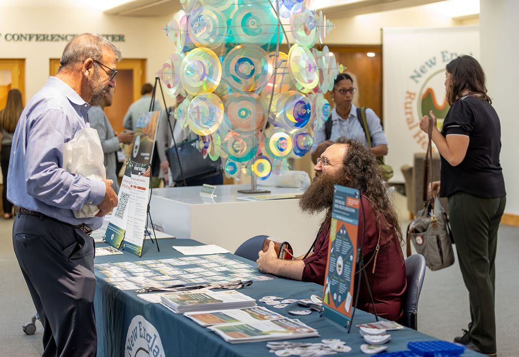 Daniel Merrigan visits the New England Rural Health Association information booth during NERHA's 2025 Rural Health Student Summit. Photo: Lars Blackmore