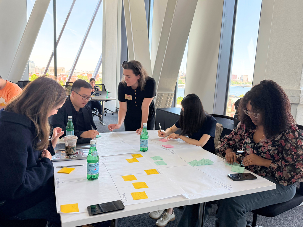 The graduate student summer fellows work with Katie Atherton, a policy associate at BU IGS, in a research translation workshop. Photo: Alison Gold, BU Institute for Global Sustainability