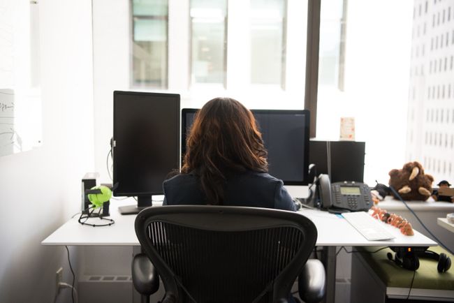woman-sits-at-desk-facing-window