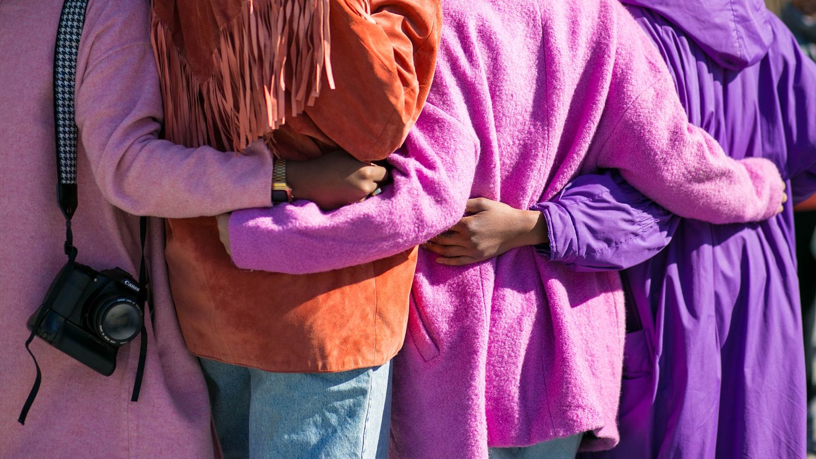 people-in-coats-put-their-arms-around-each-other