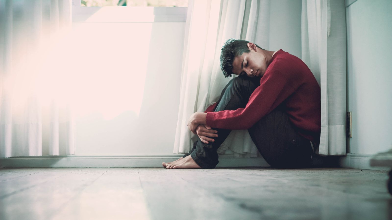 depressed-teen-sits-on-floor