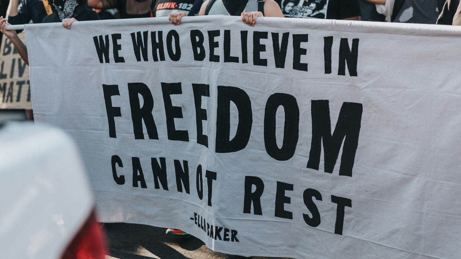 protesters-hold-banner-we-who-believe-in-freedom-cannot-rest