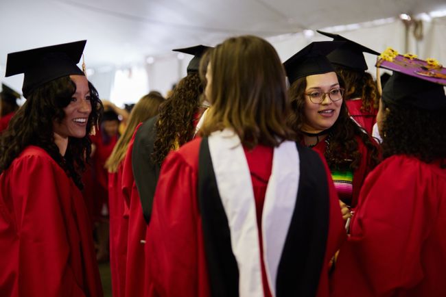 Graduates mingle outside in the line-up tent