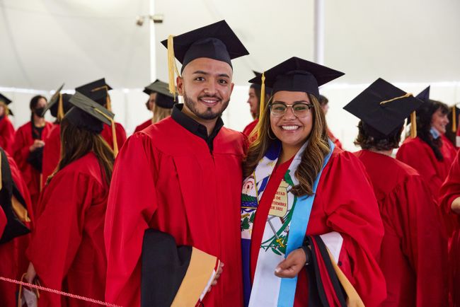 Two graduates pose for a picture in the line-up tent