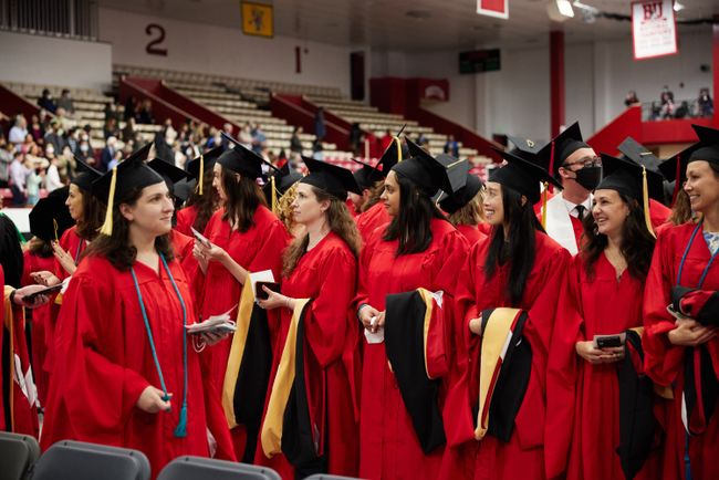 Grads stand up at their seats as the procession continues