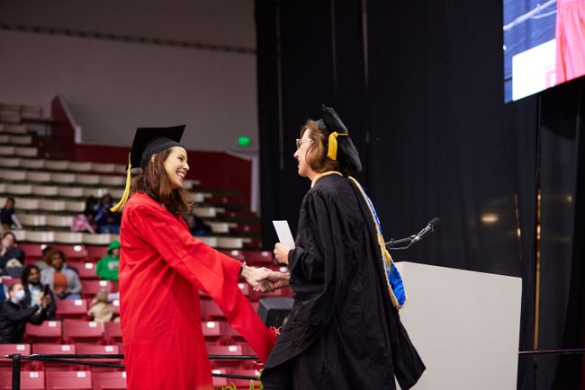 A grad receives an award from Prof. Furlong