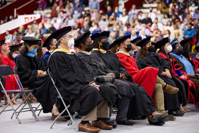 Faculty and ceremony participants watch Dean Delva from their seats