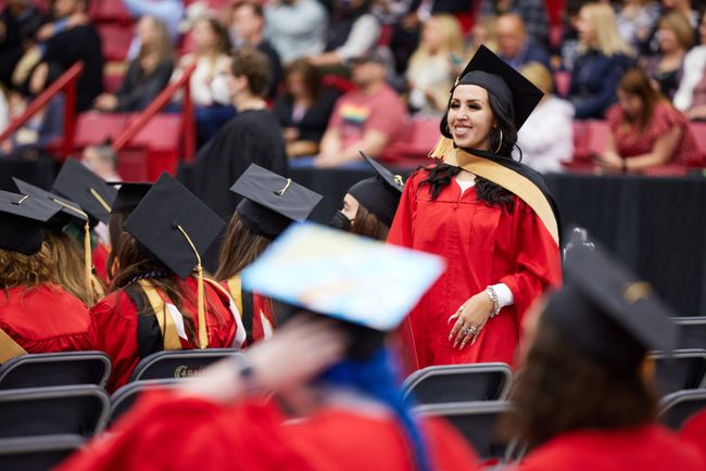 A graduate walks back to their seat after receiving their diploma