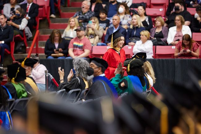 A graduate returns to their seat after receiving their diploma
