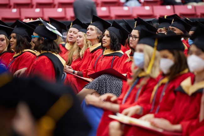 Seated graduates look up at the stage