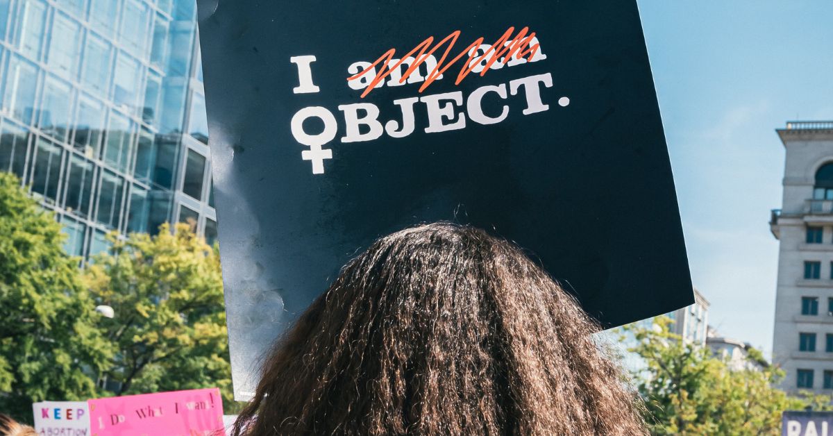 woman protests with sign that says I object