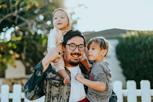 father and children smile for family portrait