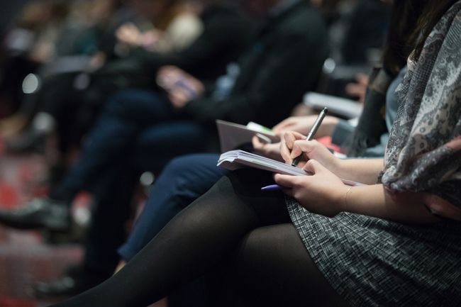 people taking notes at a conference