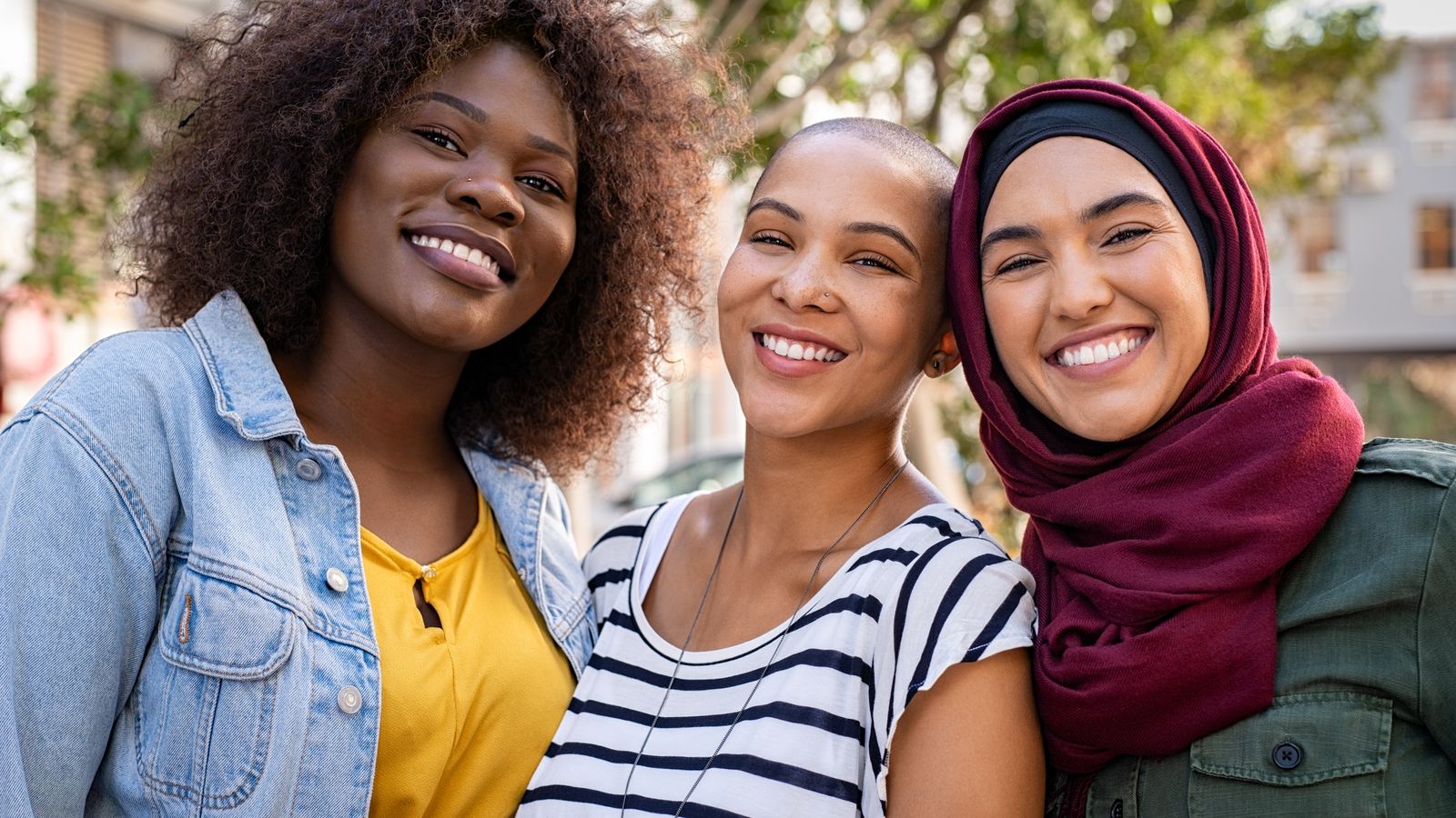 Three students smile for a photo