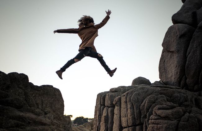 woman leaping over a crevasse