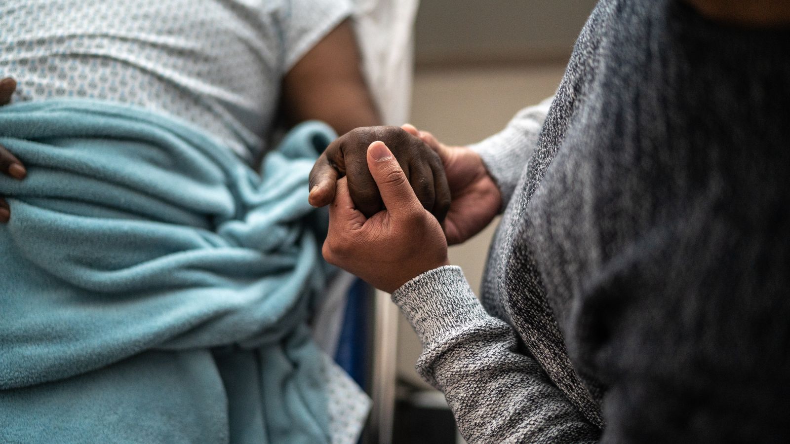 two people holding hands in hospital