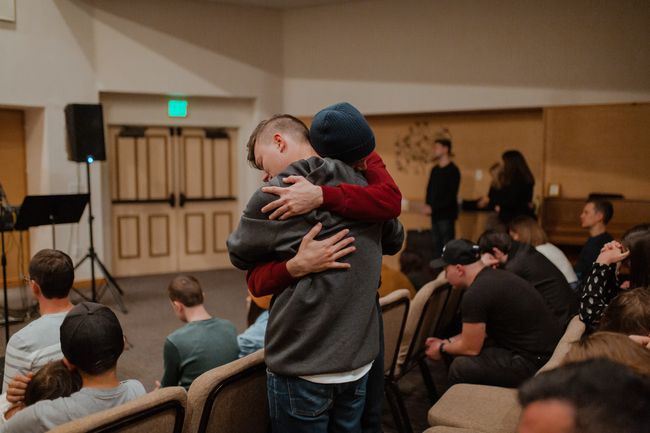 two people hugging at a support group