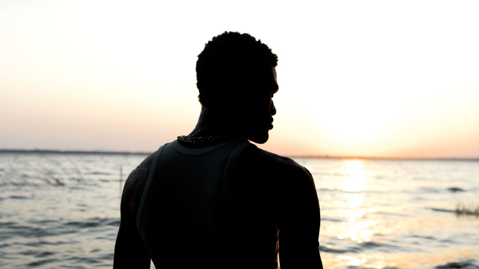 a man silhouetted against the ocean