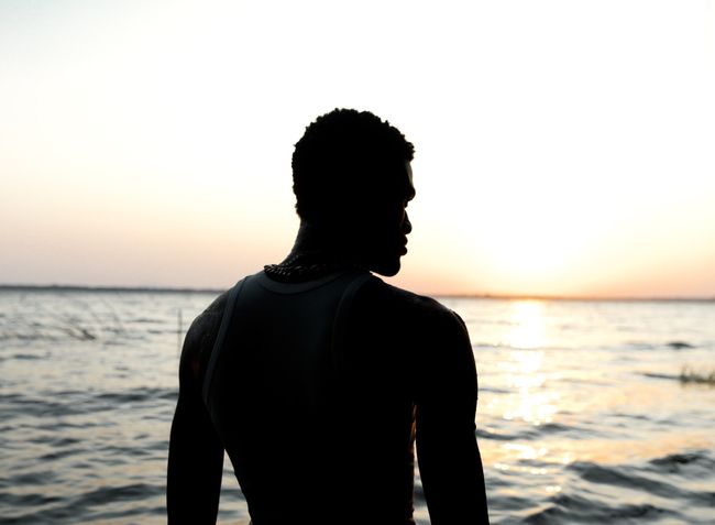 a man silhouetted against the ocean