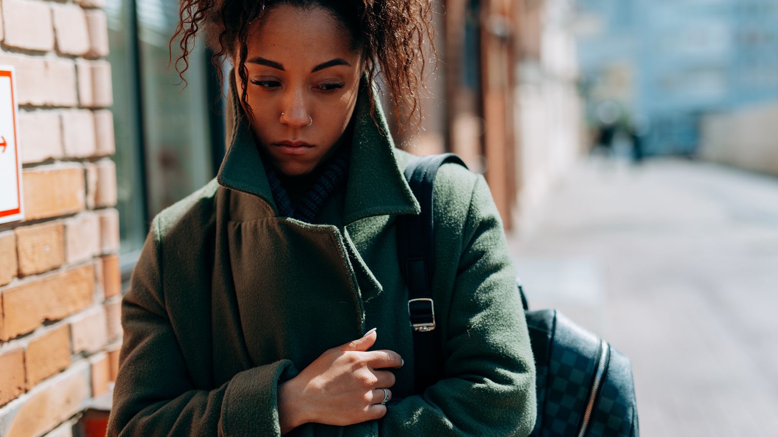 a sad woman walking down the street