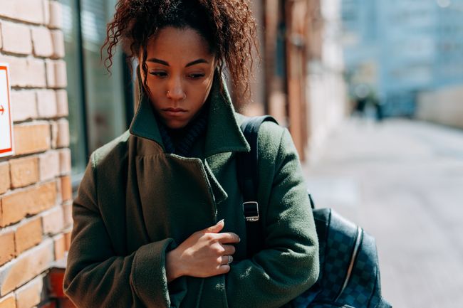 a sad woman walking down the street