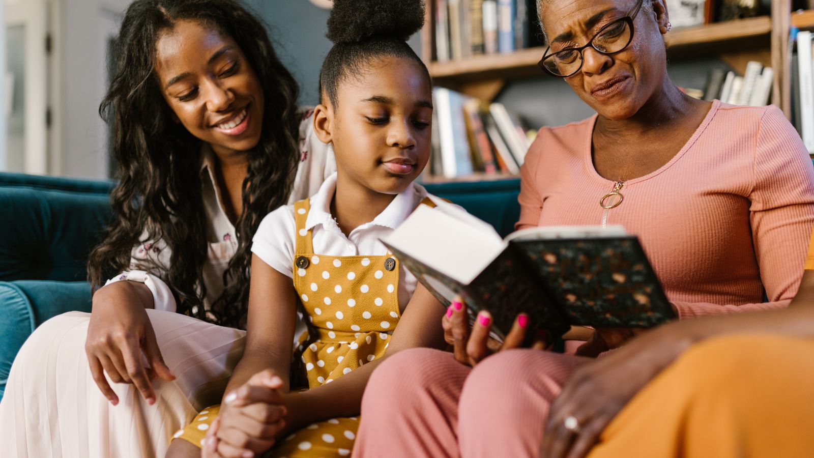 Three generations of Black women reading a book