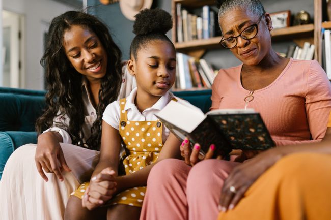 Three generations of Black women reading a book