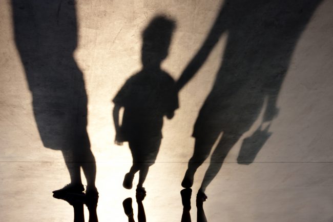 shadows of a child being taken away from a parent