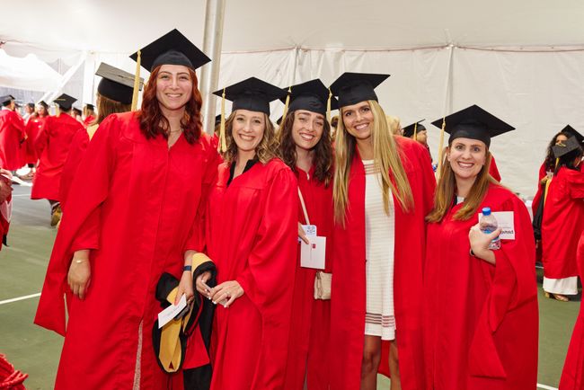 Graduating students in red robes pose for photo