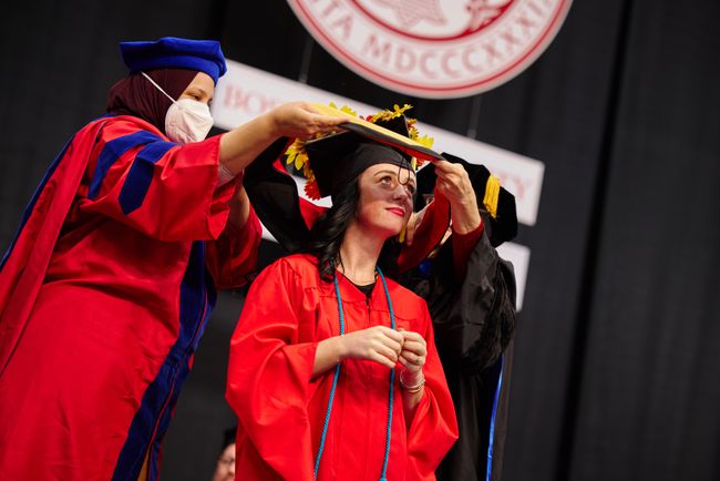 Graduating student is hooded on stage