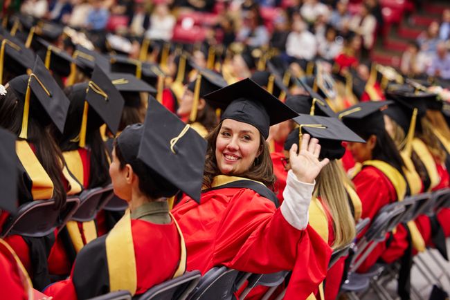 Seated graduate turns and waves