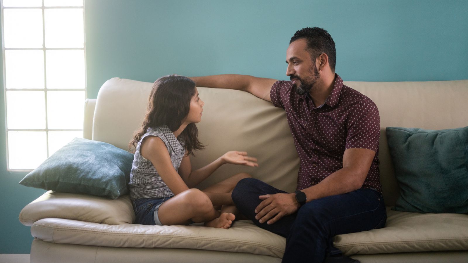daughter talking to father on couch