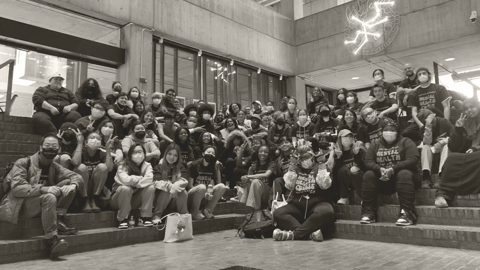 Black and white photo of dozens of young people posing for picture in Mental Health Crisis Response t-shirts