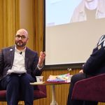 Photo of the event moderator and author on stage