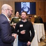 Photo of event moderator and attendee at the reception