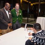 Photo of BUSSW Prof. Luis Alvarez-Hernandez signing a copy of See Me! during the reception and book signing