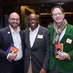 Event attendees posing for a photo during the reception, holding copies of the book