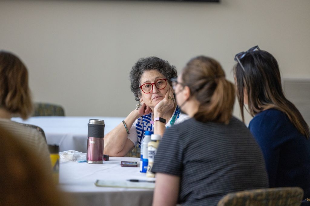 workshop attendees sitting at table listening to each other