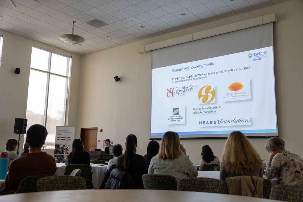 Presentation screen with attendees looking on