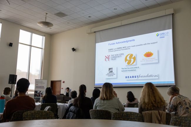 Presentation screen with attendees looking on