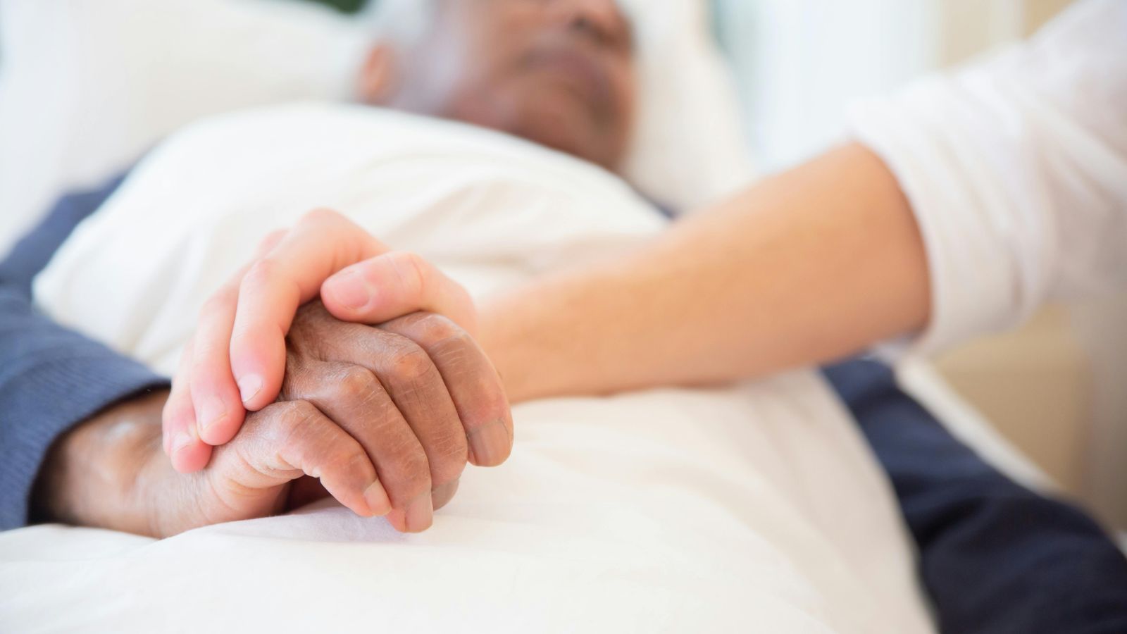 person holding hand of patient lying down