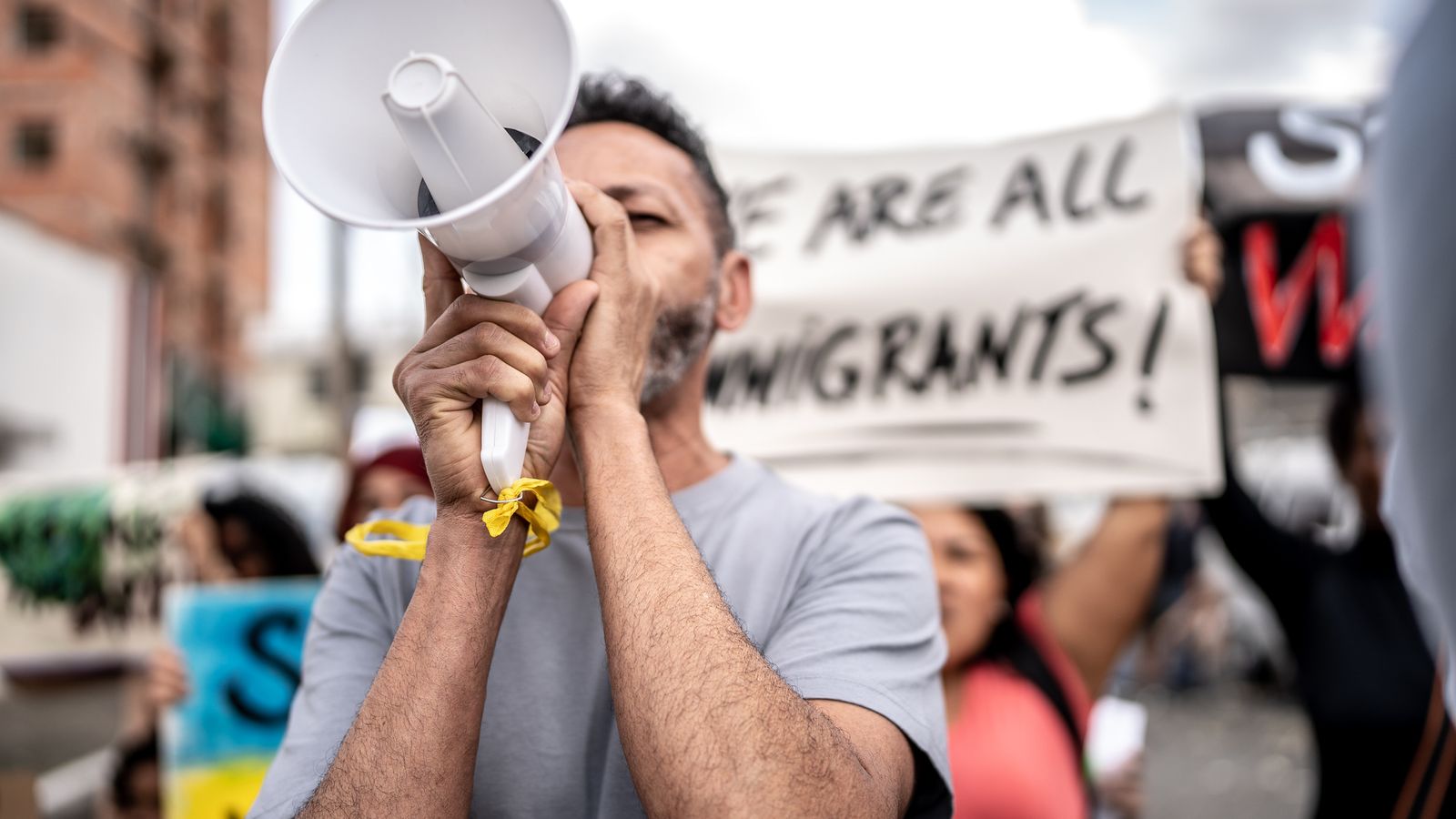 Mature man talking in a megaphone during a protest in the street