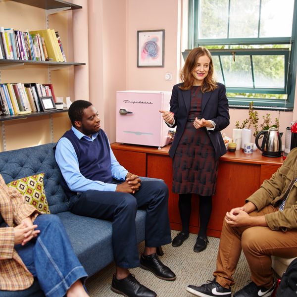 dean of students and community life talking inside with students in her office