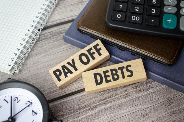 pay off debts symbol, wooden blocks