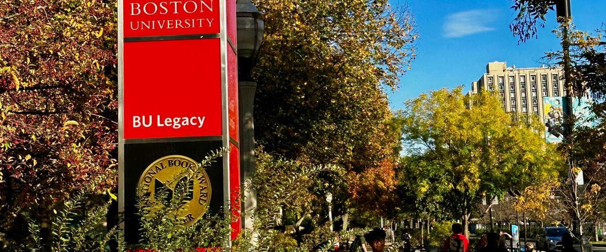 BU Legacy Sign with Students Walking By