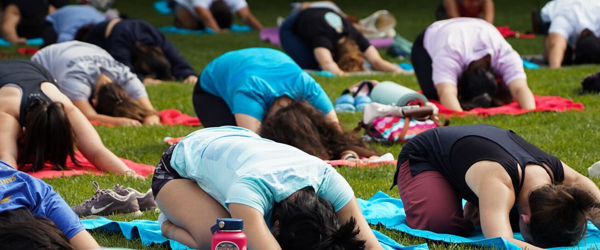 Students participate in a yoga class at BU Beach, part of Boston University's Charles River campus.