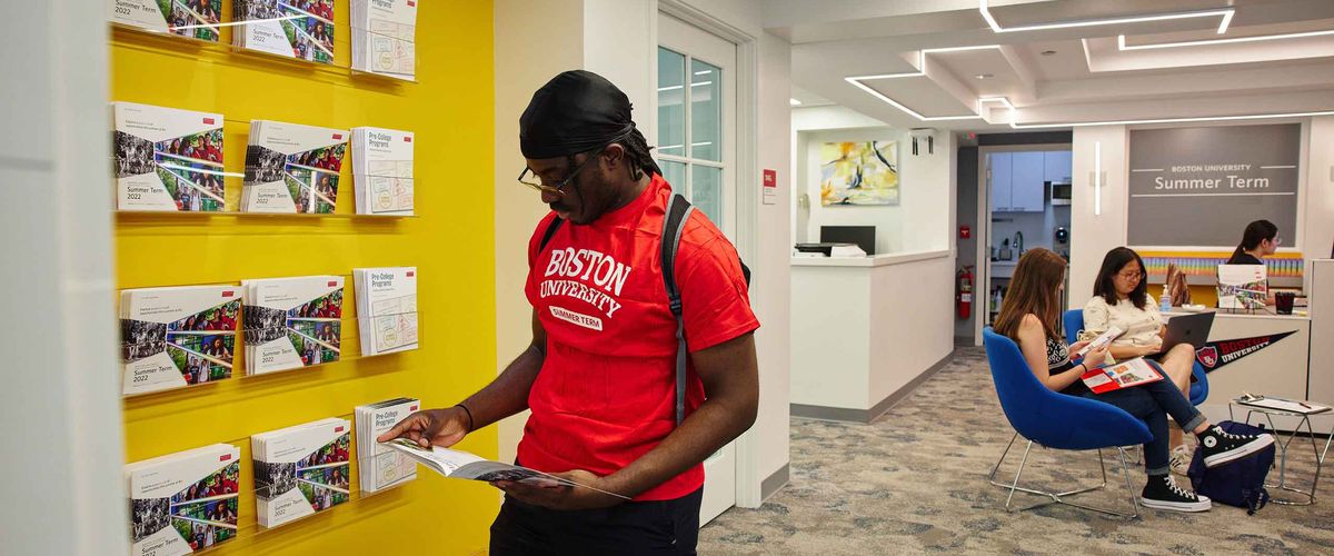 Student reading a brochure in the Boston University Summer Term office