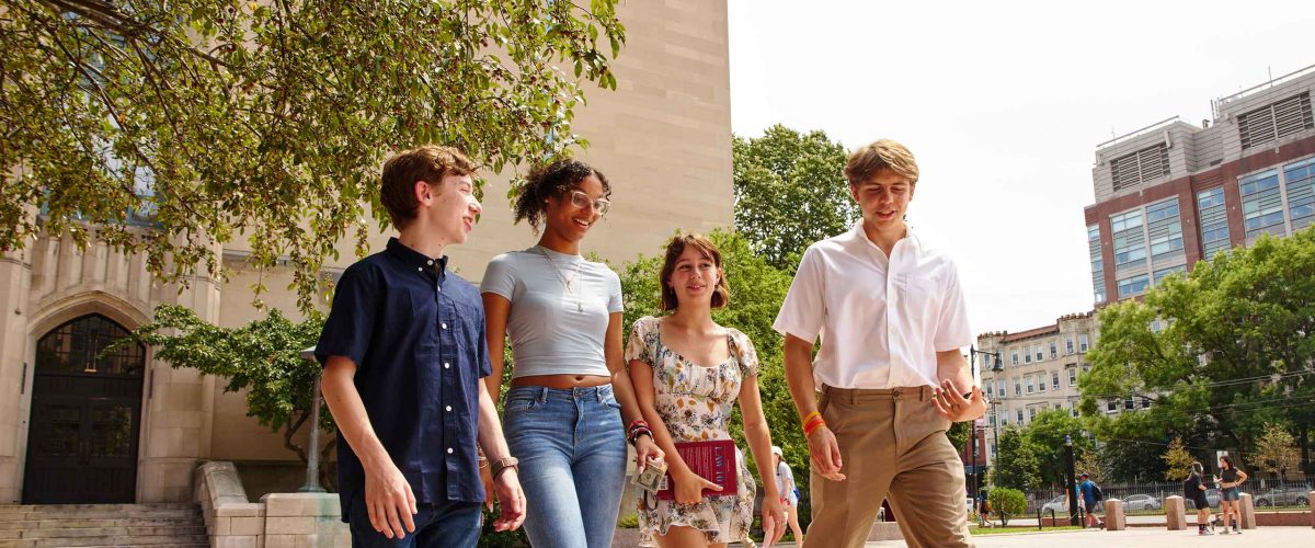 Four Boston University students walk outside.