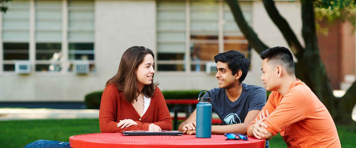 Boston University students sitting at a table outdoors